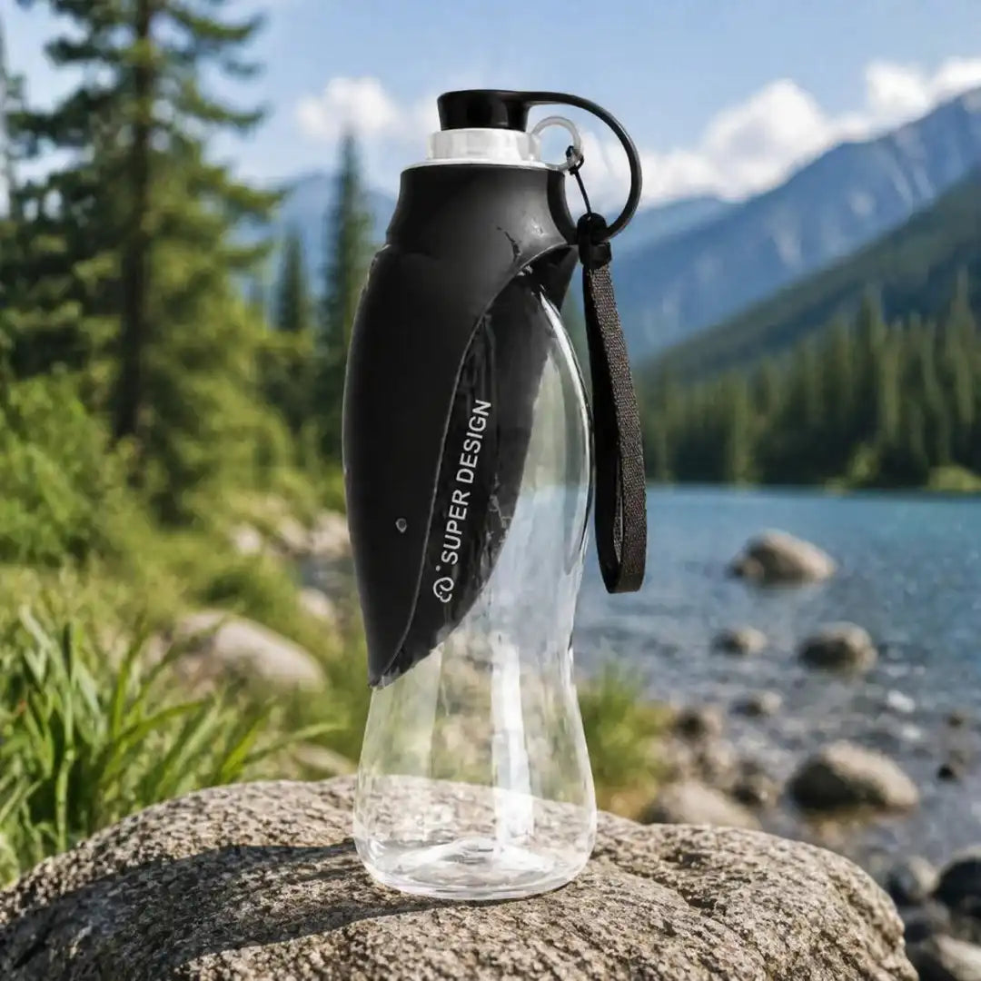 Portable pet water bottle for travel with integrated drinking cup tray shown extended for a dog